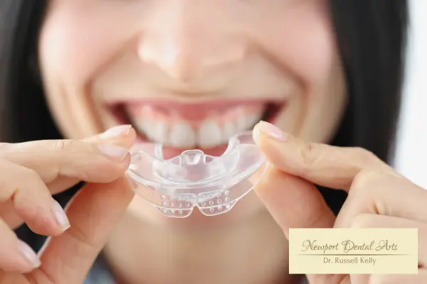 Newport Beach dentist fitting a young athlete with a custom sports mouth guard to protect teeth during fall school sports season