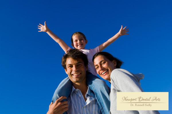 Newport Beach family smiling during beach outing, representing proactive dental care and preventive dentistry